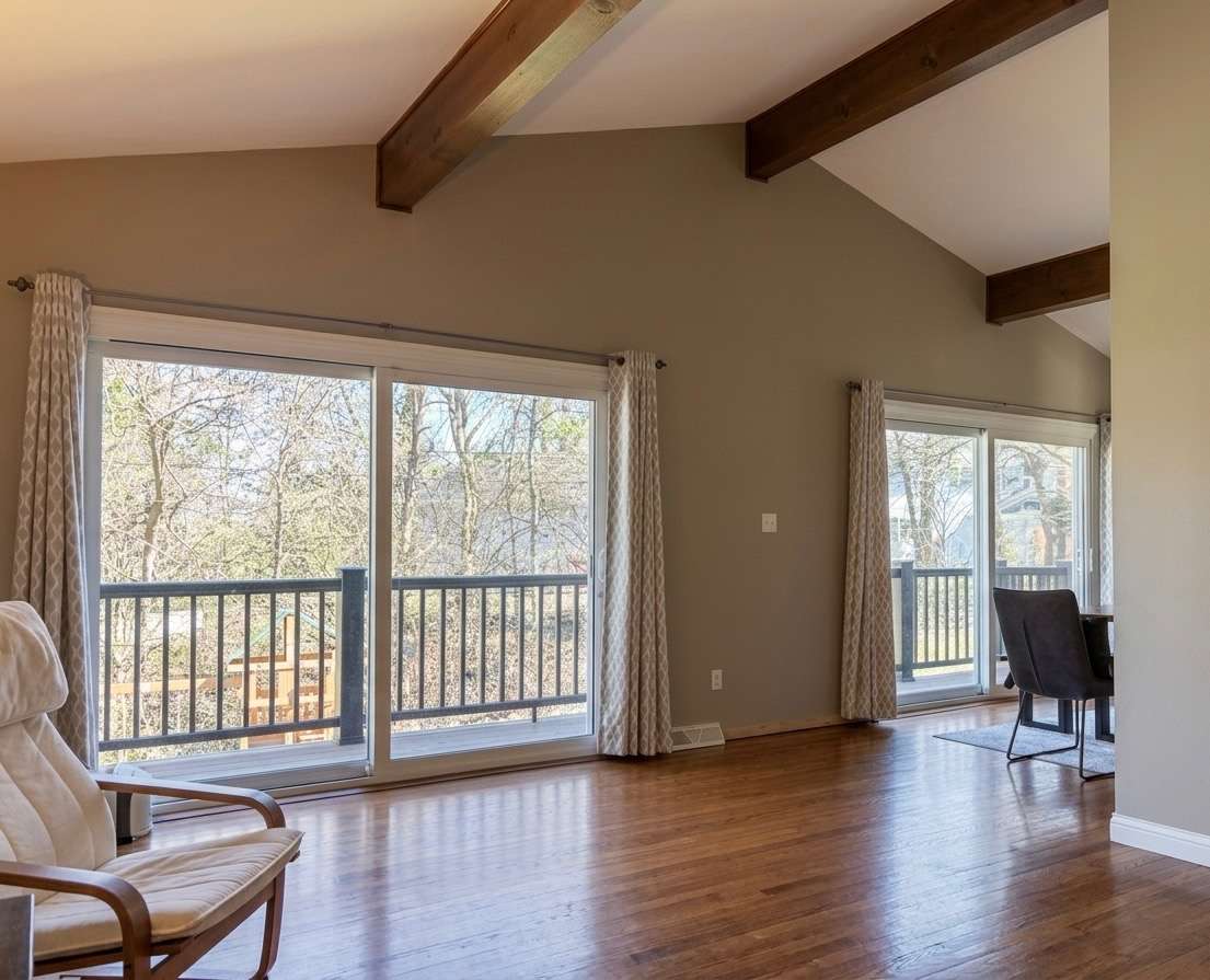 Family room with oversized glass sliding doors looking out to private backyard nature view